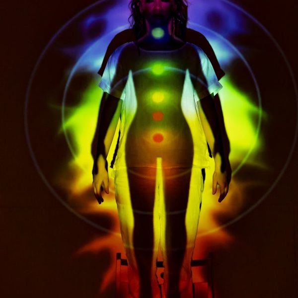 Silhouette of a person meditating with an energetic aura.